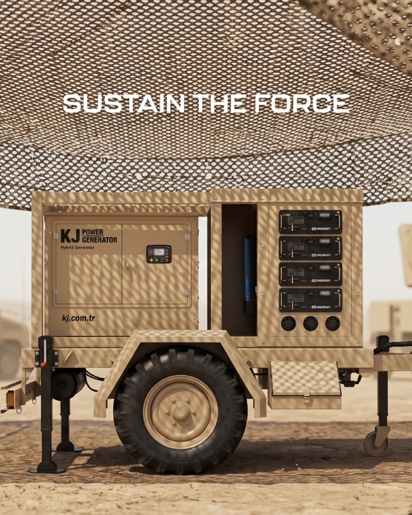 Kum rengi bir mobil jeneratör, üzerindeki teknik kontroller ve düğmelerle görünmekte. Arka planda askerî bir alan var ve üstte 'Sustain the Force' yazıları yer almakta.