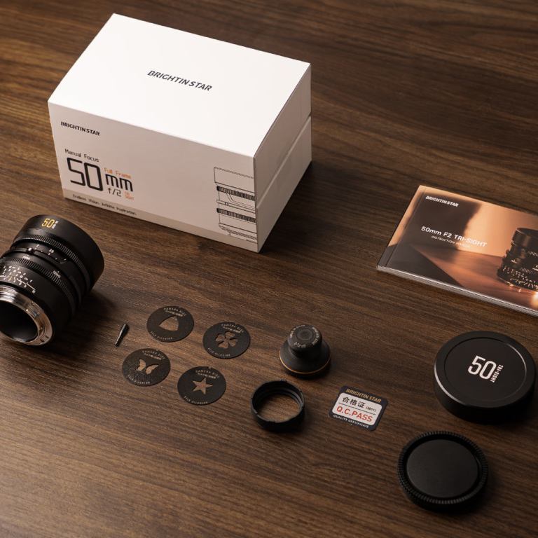 Ahşap masa üzerinde Brightin Star 50mm kutusu, lens, kapaklar ve yıldız, kelebek, yonca, üçgen biçimli arka bokeh aparatları