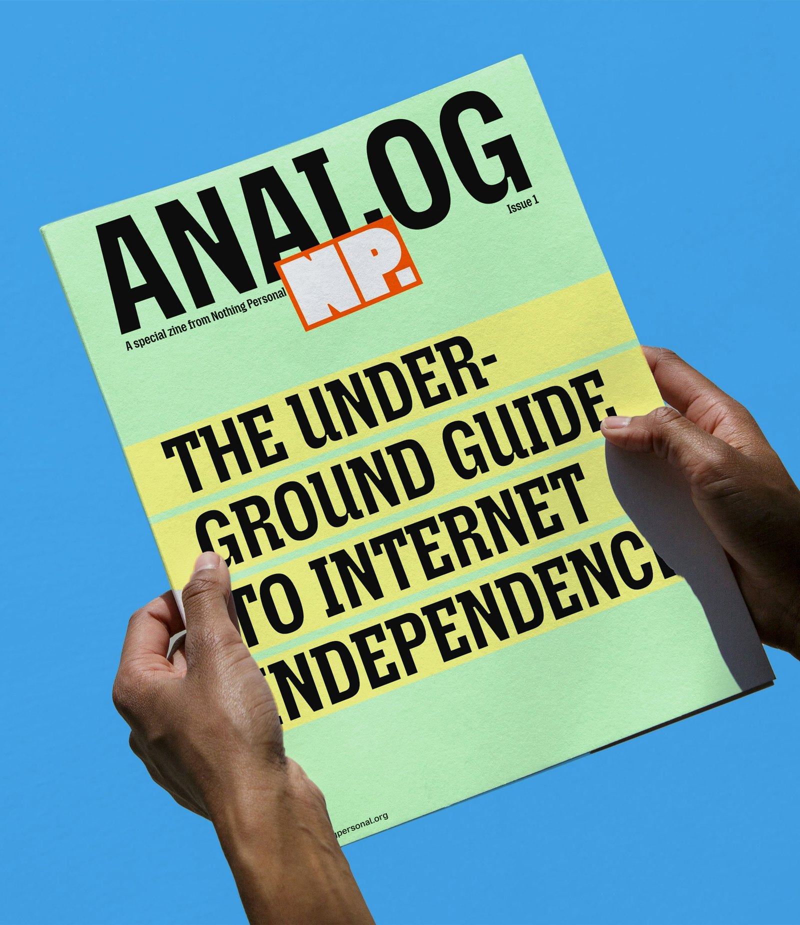 Mavi zemin önünde tutulan “Analog: The Underground Guide to Internet Independence” başlıklı yeşil-sarı dergi