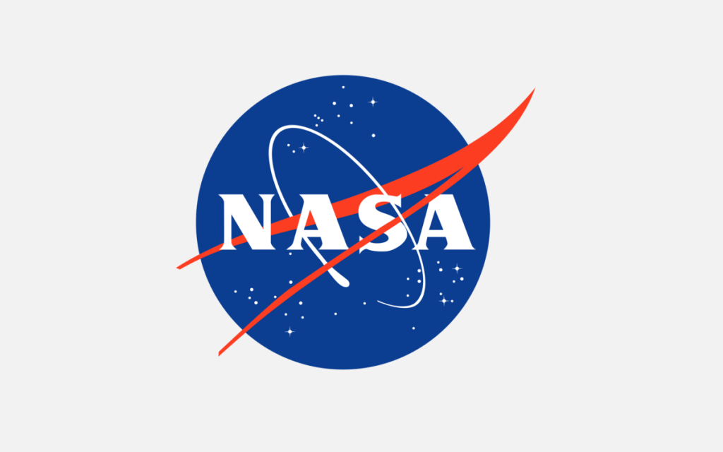 Mavi daire içinde beyaz NASA yazısı, yıldızlar, yörünge çizgisi ve kırmızı vektör kanadından oluşan NASA meatball amblemi